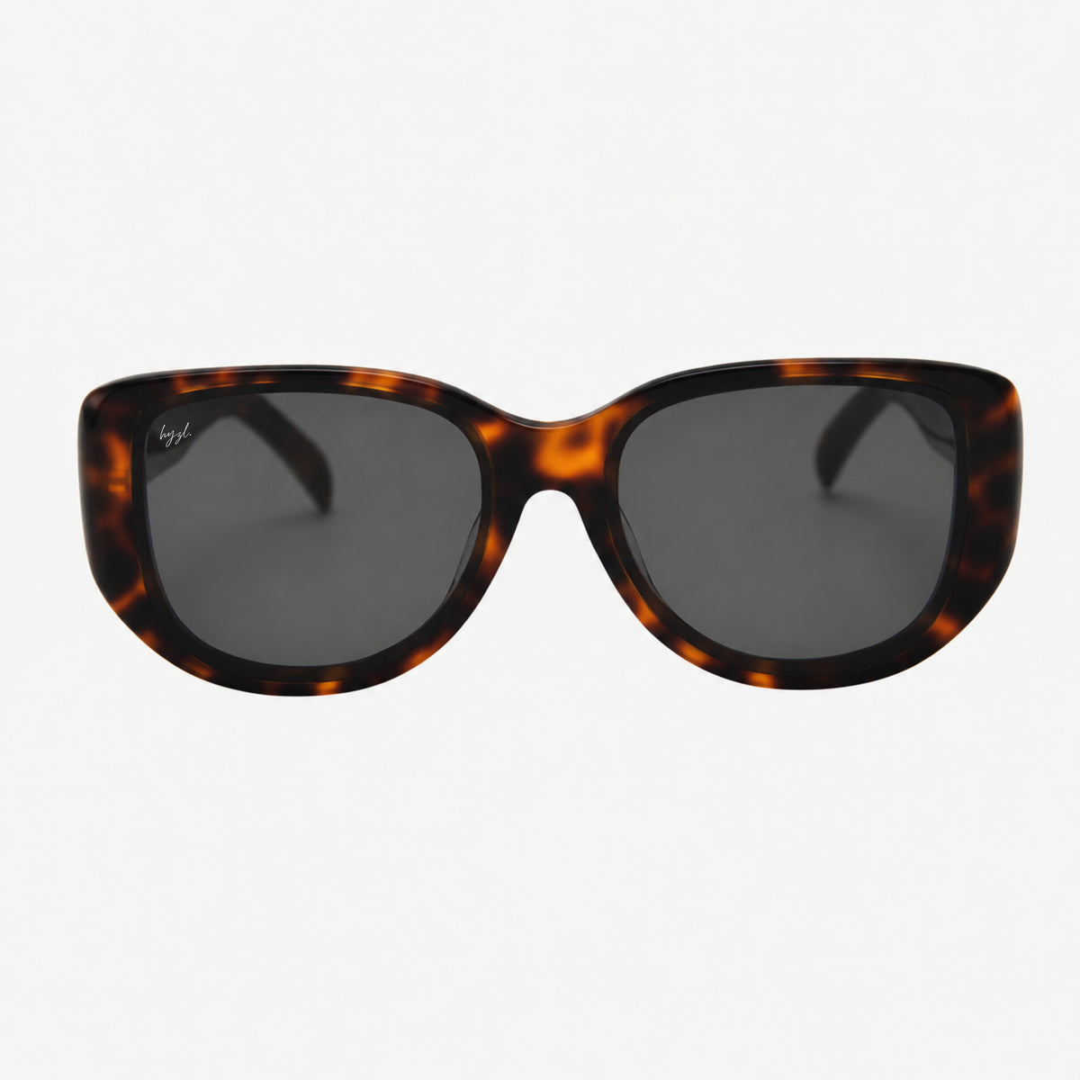 Hyzl sunglasses with a dark brown and amber tortoiseshell acetate frame and dark gray lenses, shown against a light gray background.