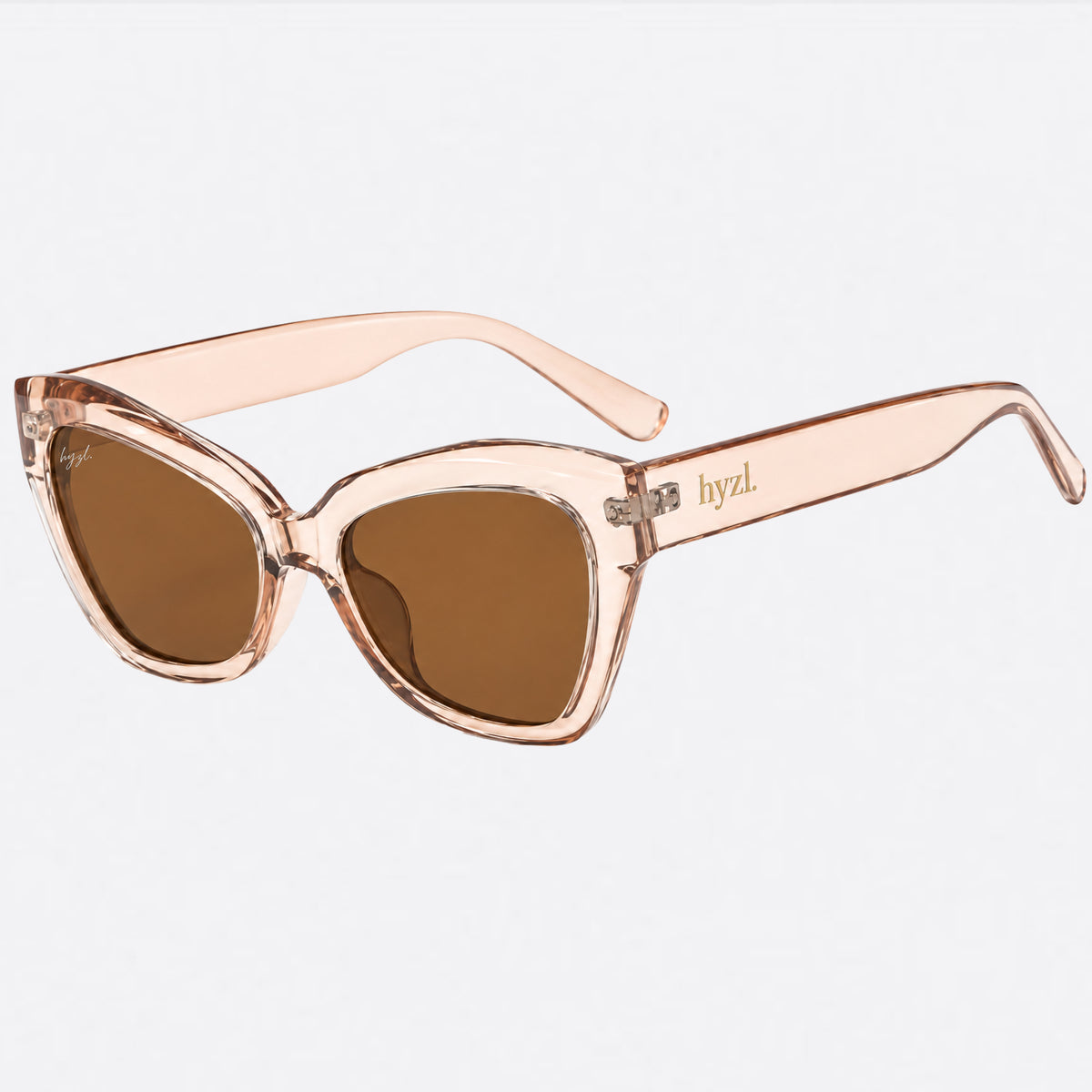 Cat-eye sunglasses with a translucent rose gold frame and brown lenses, featuring the brand name 'hyzL' printed on the temple arm, set against a plain light gray background.