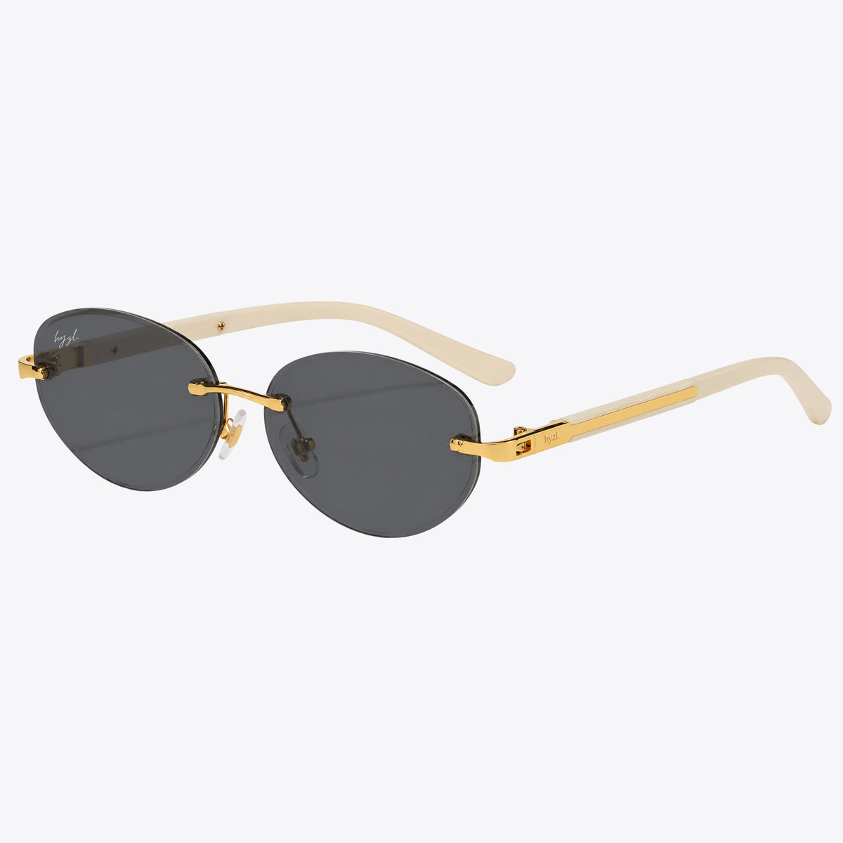 Hyzl sunglasses with dark gray lenses, gold metal rims, and cream-colored temples, shown on a light gray background.