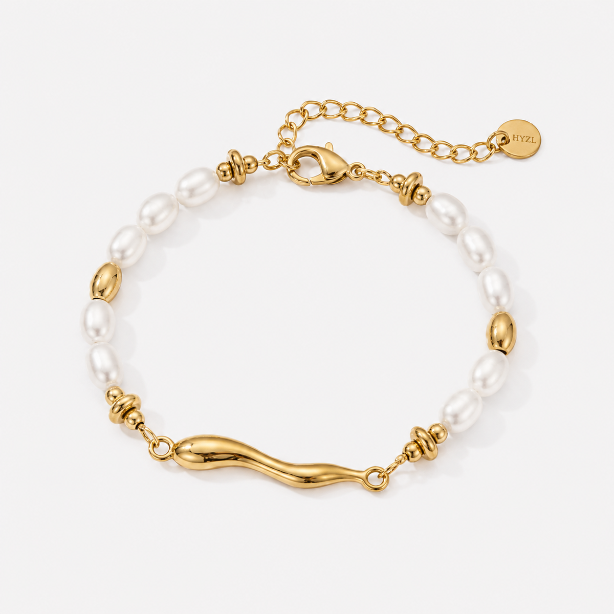 A gold and white pearl bracelet featuring a polished gold wave centerpiece, gold spacer beads, and an adjustable gold chain clasp with a round brand tag.